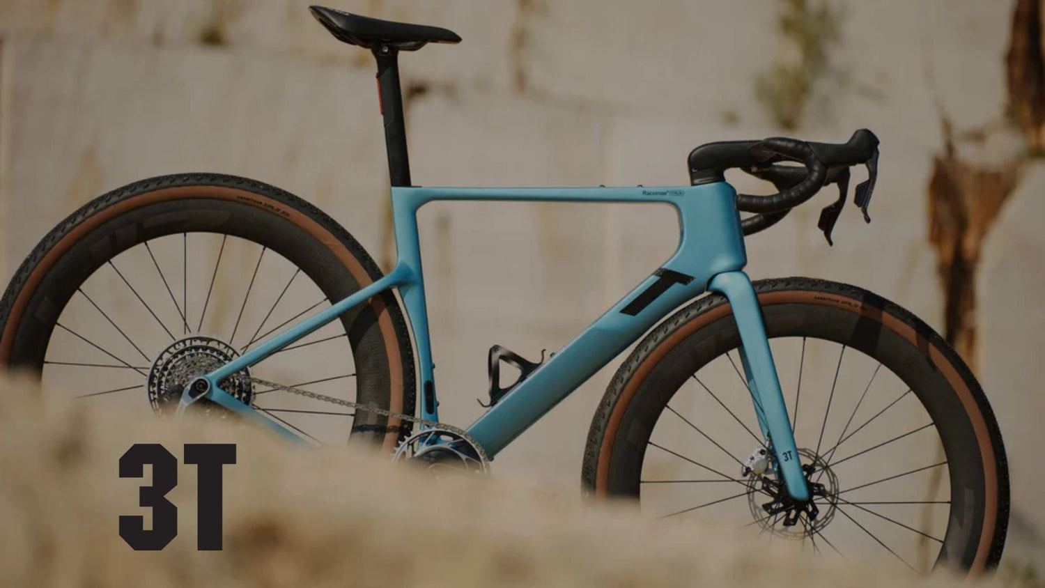 A blue 3T bike self standing on a gravel descent.