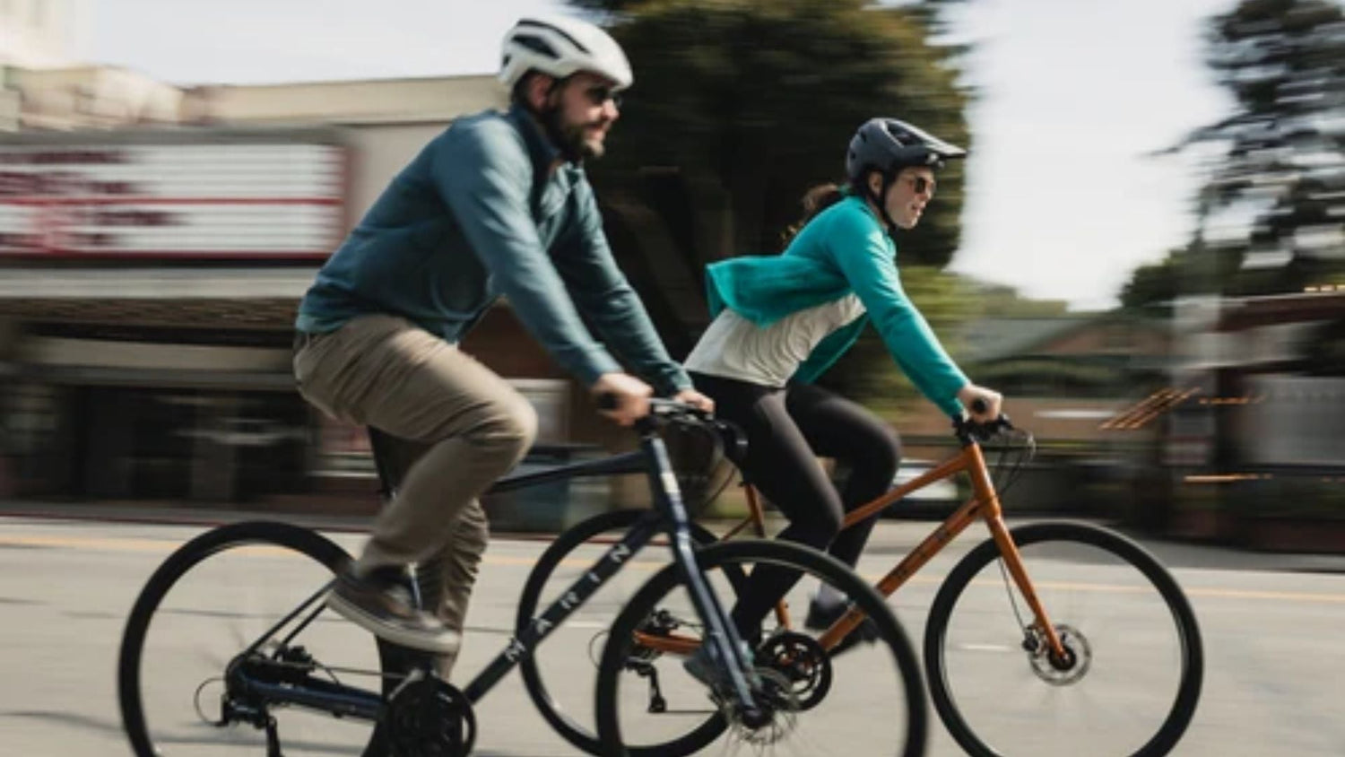 Marin Fairfax and Marin Kentfield hybrid bikes parked outside a café, showcasing fitness-focused and comfort-focused urban cycling styles.